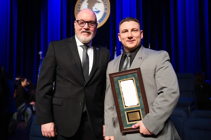 Two people one with award in hand