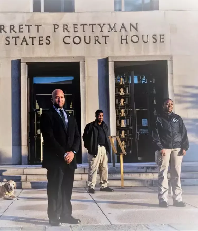 US Court house with 3 men and a woman standing outside